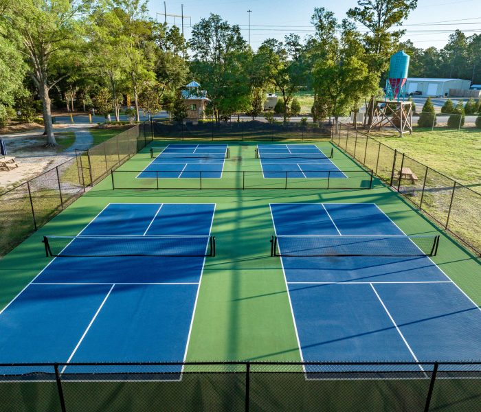 Aerial view of four pristine pickleball courts at Splash RV Resort in Milton, Florida