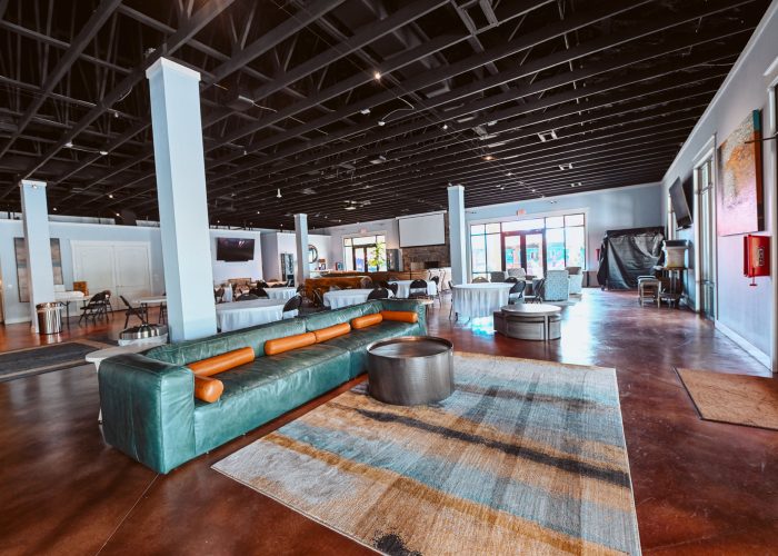 Spacious modern clubhouse interior at Splash RV Resort in Milton, Florida with teal leather seating and industrial design elements